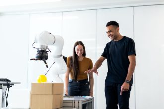 Dois engenheiros testam um protótipo robótico em um laboratório moderno de inovação.