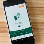 Smartphone exibindo uma interface de detecção de contatos sobre uma mesa de madeira
