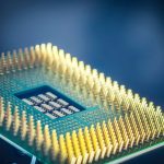 Imagem em close de um chip de computador com contatos dourados sobre fundo azul.